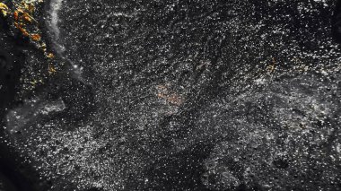 Sparkling background. Grain texture. Night sky. Defocused shimmering metallic silver black golden color glitter on dark abstract free space.