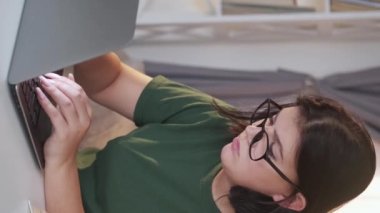 Vertical video. Tired freelancer. Project deadline. Overwork fatigue. Exhausted sad unhappy woman working online typing using laptop at home workplace.
