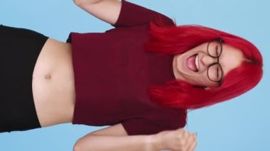 Vertical video. Winner joy. Victory celebration. Happy overjoyed excited lucky girl shouting clenching fists on blue background seamless loop.