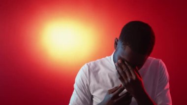Mistake regret. Failure disappointment. Sorrow despair. Upset ashamed tired man covering face on red orange gradient copy space background.