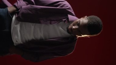 Vertical video. Relaxation trance. Sound chill. Hypnotic music. Calm tranquil guy enjoying slow dancing movements singing along on dark red.