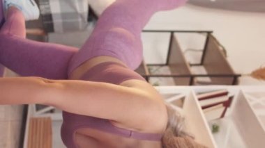 Vertical video. Aerobics workout. Athletic woman. Fitness recreation. Motivated sportswoman in activewear exercising glute legs workout at home.