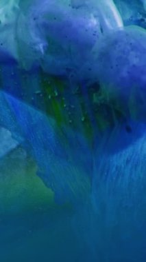 Vertical video. Fluid splash. Paint water. Explosion fume. Blue green color ink flow smoke cloud motion over glass cube angle abstract background.