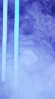 Vertical video. Neon smoke. Blur light. Vapor flow. Defocused blue color LED glow steam floating on abstract free space background.