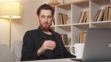 Self-confident man. Masculine power. Successful business. Happy stylish macho male sitting desk opened laptop taking care hairstyle in light room interior.