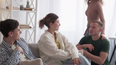 Close friends. Inspired communication. Home meeting. Happy two male and female couple enjoying talk together in light room interior.