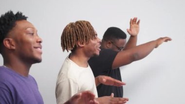 Funny joy. Happy black men. Positive mood. Relaxed hipster guys dancing together posing in line on light background slow motion.