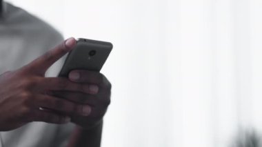 Mobile app. Digital communication. Electronic device. Closeup of male hands using smartphone texting message on light copy space background.