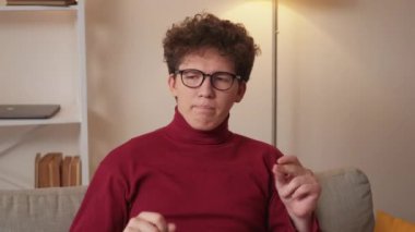 Home relax. Musician man. Enjoying time. Funny inspired guy singing and beating music gesturing hands sitting sofa light room interior.