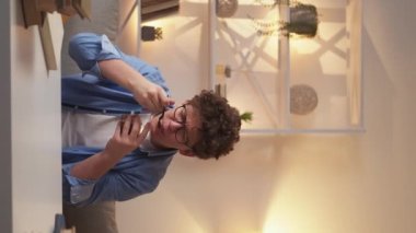 Vertical video. Delicious noodles. Excited man. Fast dinner. Casual happy guy eating testy fast food sitting desk in light room interior.
