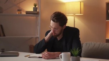 Hard work day. Tired man. Relaxed massage. Exhausted business man sitting desk hot beverage pressing neck in light room interior.