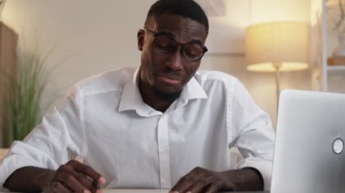 Work fatigue. Overworked businessman. Report deadline. Exhausted man yawning sleeping on desk with opened laptop in light office interior.