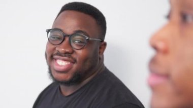 Happy black men. Positive mood. Model shooting. Smiling friendly guys posing staying in line on light wall background motion view.