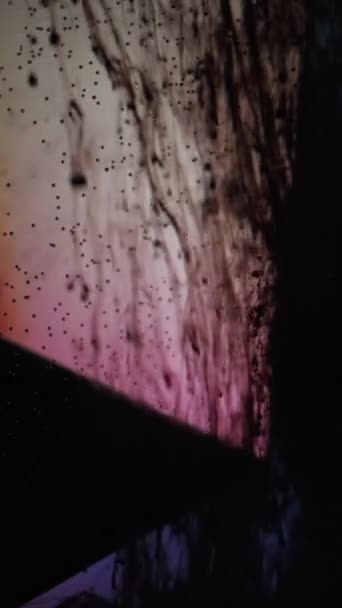 垂直ビデオ インクを落とせ 水を塗れ 煙の流れ 黒液滴の動き泡ガラスキューブ縁に青ピンクダークグランジ抽象的な背景 — ストック動画