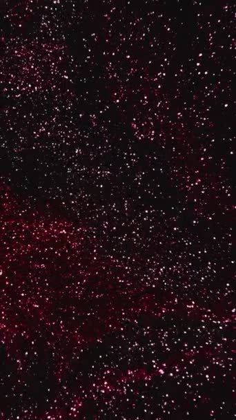 垂直ビデオ 輝く液体 ペイントフロー 宇宙塵だ 暗い抽象的な背景に光沢のある赤の黒の輝きのテクスチャインクの動き — ストック動画