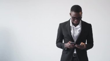 Mobile banking. Online transaction. Payment app. Happy man executive using phone with credit card for e-commerce money transfer on white copy space.