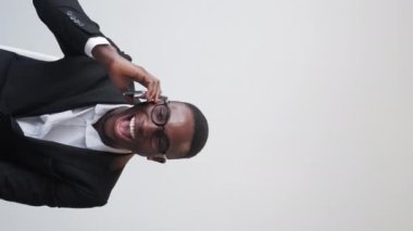Vertical video. Winner joy. Successful man. Business call. Overjoyed excited guy screaming yes on phone call on white background copy space.
