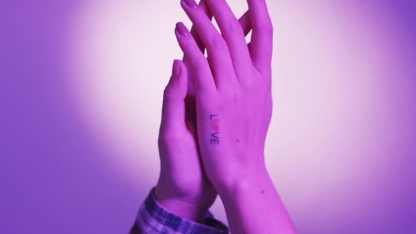 二人とも ロマンチックなデートだ ネオンライトの人々 二人の女性を保持し 手に触れるとともに入れ墨愛上の1ポーズ青紫色の背景 — ストック動画