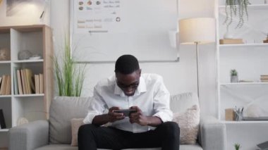 Gezici oyun. İş molası. Gadget 'ın boş vakti. Neşeli milenyum adamı yönetici telefon uygulaması oynuyor ofis koltuğunda siber sporun tadını çıkarıyor.