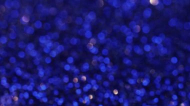 Defocused lights. Blue background. Spangle magic. Bright electric color tinsels shining and blinking macro shooting blur lens flare.