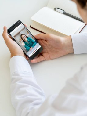 Mobile conference. Video call. Corporate telecommuting. Business partners discussing work online on phone screen at office workplace.