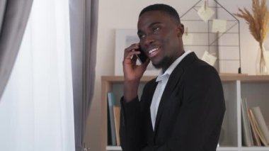 Male leadership. Business call. Professional cooperation. Successful happy man executive talking on phone conversation at office window.