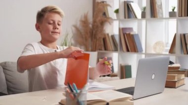 Online eğitim. Tatmin olmuş çocuk. Dersini bitir. Laptop 'ta çalışmayı bitirdikten sonra mutlu bir genç kendini rahatlamış hissediyor..