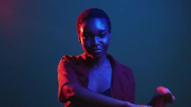 Kazanan dans. Başarı kutlaması. Olumlu tepki. Kırmızı mavi neon rengi ışık tatmin edici zaferin tadını çıkaran kadın karanlık gece gif loop bumerang animasyonunda tek başına hareket ediyor..
