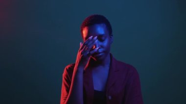 Yüz jesti. Yazık oldu. Utanç acısı. Kırmızı mavi neon rengi, hayal kırıklığına uğramış yüzünü kaplayan kadın, karanlık gece gif döngüsü bumerang animasyonunda yalnızdır..