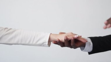 Colleague support. Corporate help. Office romance. Unrecognizable multiracial man woman partners holding hands on light background.