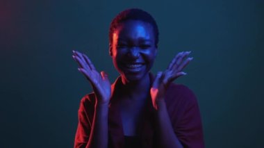 Omg reaksiyonu. Başarı sevinci. Zafer kutlaması. Kırmızı mavi neon rengi ışık şaşkın kazanan kadını heyecanlandırıyor zaferin tadını çıkarıyor karanlık gece gif loop bumerang animasyonunda.