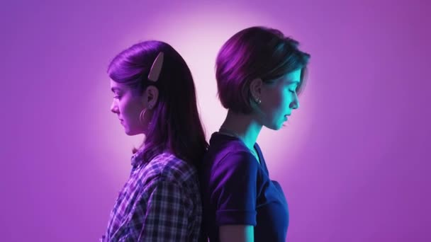 值得信赖的友谊 女性支持 霓虹灯下的人快乐的两个女人在绿紫的背景下彼此依偎在一起 — 图库视频影像