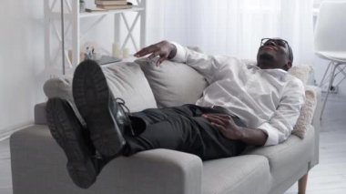 Work relax. Job break. Office rest. Peaceful happy man employee laying on comfortable couch satisfied with solving business problem.