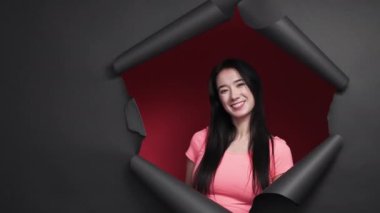 Happy woman. Feminine beauty. Positive portrait. Pretty smiling female in casual look posing on red background black disrupted paper frame.