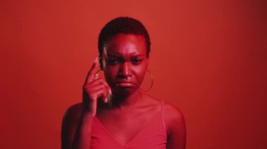 Yüzün asık. Depresif ruh hali. Hücum pişmanlığı. Kırmızı neon rengi ışık mutsuz üzgün kadın ağlayan gözyaşı gösteren jest koyu parlak gif bumerang animasyonunda izole edilmiş.
