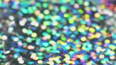 Colorful shiny lights. Festive background. Defocused magic. Green yellow blinking illumination with glitter tinsels surface bokeh macro shooting.