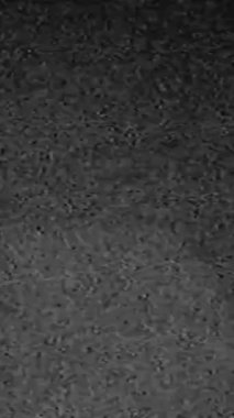 Vertical video. Grain noise analog glitch. 35mm filmstrip effect. Black white real static distortion old TV bad signal abstract background.