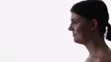 Gülümseyen kadın. Siluet profil portresi. Tarafsız makyajlı, kısa saçlı, beyaz arka plan fotokopi alanı pozu veren pozitif kadın..
