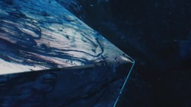 Dikey video. Boya sıçraması. Mürekkep suyu. Buz Tepesi. Mavi renk sıvısı, koyu soyut arkaplanda cam kübün üzerinde buhar akışı hareketini sağlar..