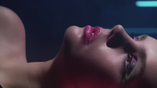 垂直录像 90年代的型号 时尚化妆 迪斯科的美 自信的少女脸庞 装腔作势 在深蓝色的霓虹灯下闪烁着红紫的光芒 — 图库视频影像