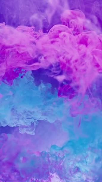 垂直ビデオ インクの水 ペイントスプラッシュ カラー爆発 ネオンピンクブルー煙雲バーストミックス浮遊運動アブストラクトアート背景ショットOn Red — ストック動画