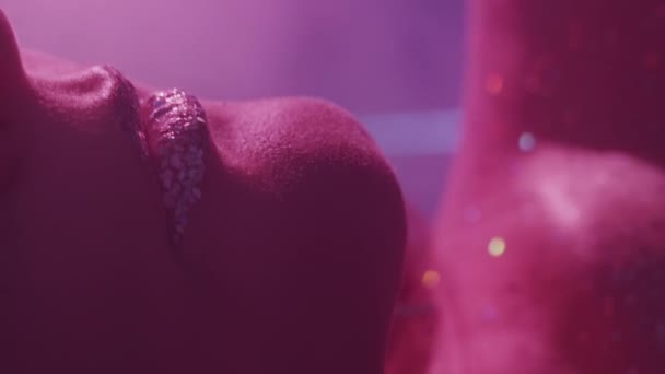 垂直ビデオ ネオンの美しさ キラキラしたメイク グラマーアート ピンク色の光の女性の顔のクロップをトリミング輝く肌の金属銀の唇 — ストック動画
