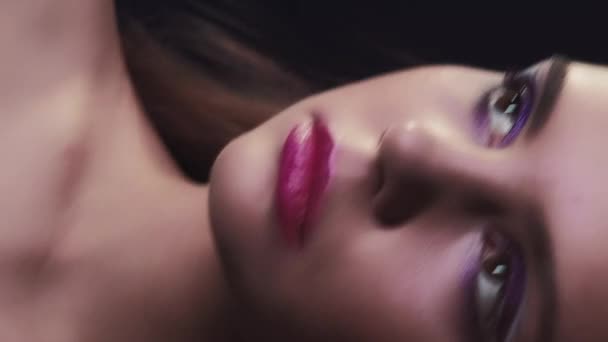 垂直录像 90年代的美女复古化妆品 2000年代时尚 浅紫色眼影少女面容的画像 浅粉唇艺术造型在霓虹灯下呈现在深黑色上 — 图库视频影像