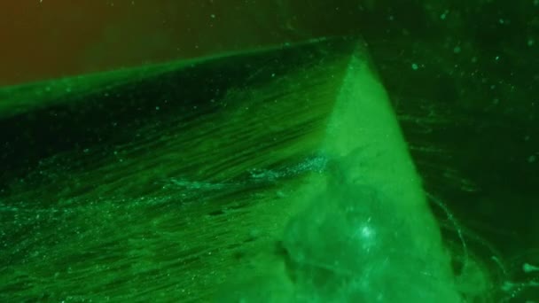 垂直ビデオ キラキラのスプラッシュ インクの水 霧のカスケード 濃い抽象的な背景にガラスキューブの角度に緑の色の塗料煙の流れの動き — ストック動画