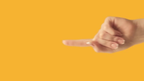 垂直录像 注意姿势这里的信息 女性的手推荐手指指向黄色空旷的空间促销背景 — 图库视频影像