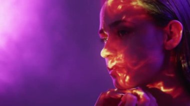 Dişi galaksi. İç güzellik. Çifte portre. Siluet kadın renkli ışık pozu veriyor dumanlı arka plan yanıp sönüyor turuncu titreşimler yansıma deseni bulanıklığı.