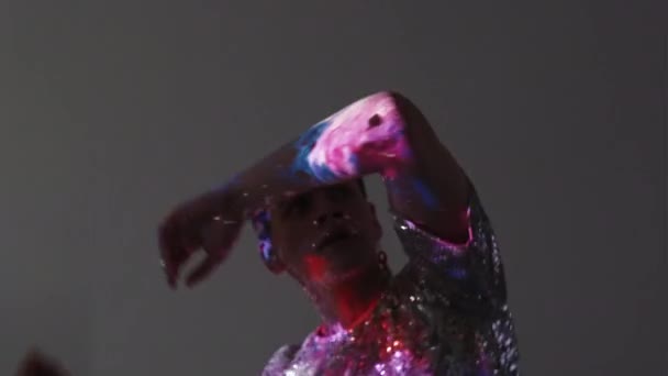 Lgbtqパーティー 男性ダンサー 二重露光魔法 スパングルシャツの静かな男虹色のイヤリングは 銀河紫色の輝きライトオーバーレイ背景とグレーに移動 — ストック動画