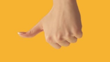 Vertical video. Feedback sign. Good bad. Survey rating. Female hand voting with thumb up down gesture on orange background set of 2 loop.