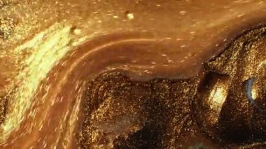 Parıltı dalgası. Mürekkep akışı. Köpüklü sıvı. Odaklanamayan, parıldayan, altın sarısı renkli baloncuklu boya hareketinin soyut arkaplanı..