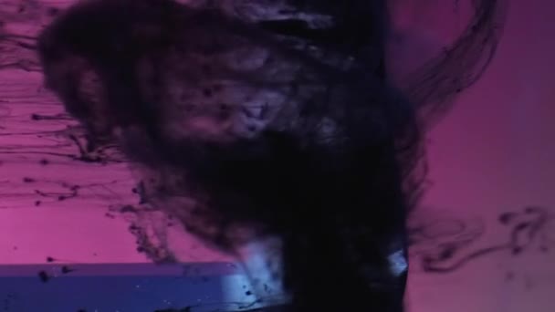 垂直ビデオ インクを落とせ 絵の具の滴 煙の流れ ピンクブルー上の黒い流体の動きネオンライトガラスキューブエッジで水に暗いグランジ抽象的な背景 — ストック動画